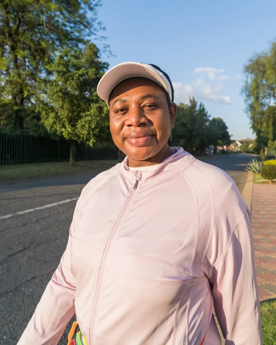 Madam O smiling on the road in her walking kit.